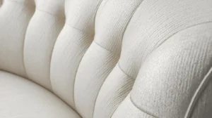Detail of white curved sofa upholstery fabric showing texture and stitching