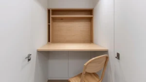 Wall-mounted drop-leaf folding table open in a very small studio apartment.