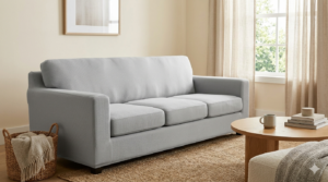 A sofa covered in a modern grey stretch slipcover, a cost-effective alternative to full reupholstery.
